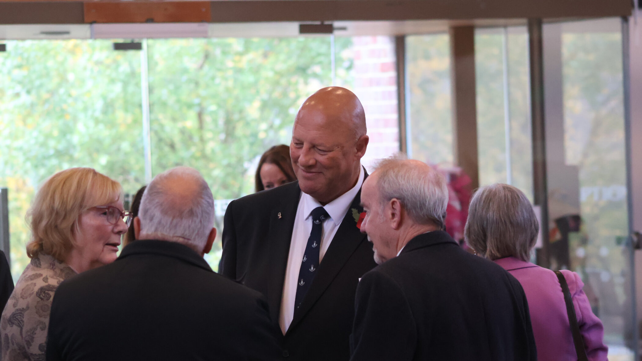 group of men and women standing in a circle chatting