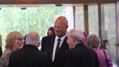 group of men and women standing in a circle chatting
