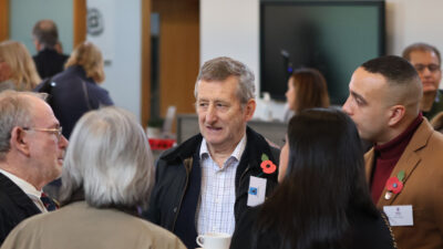 group of men and women standing in a circle at a remembrance sunday event