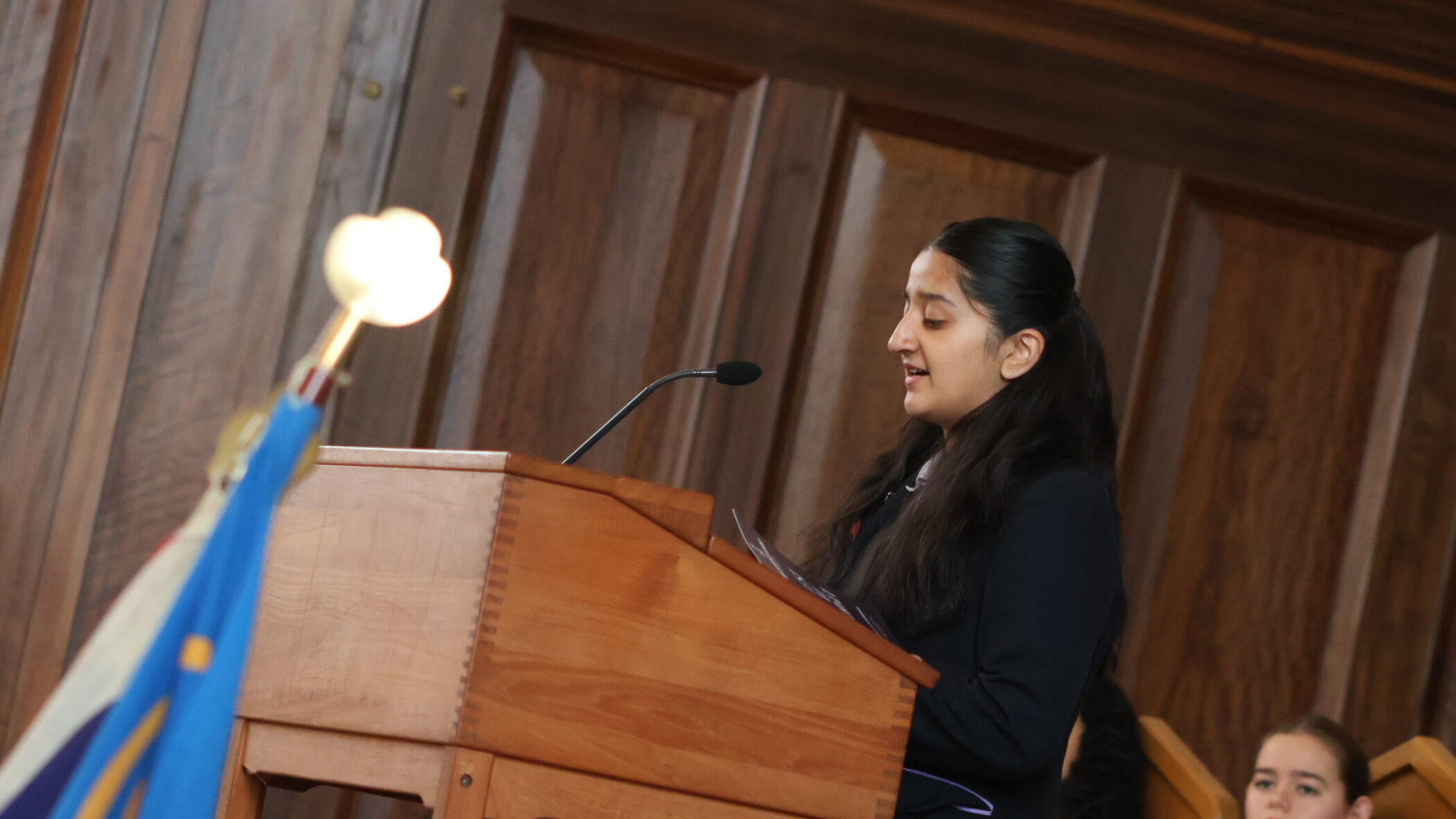 school girl giving a speech at a podium