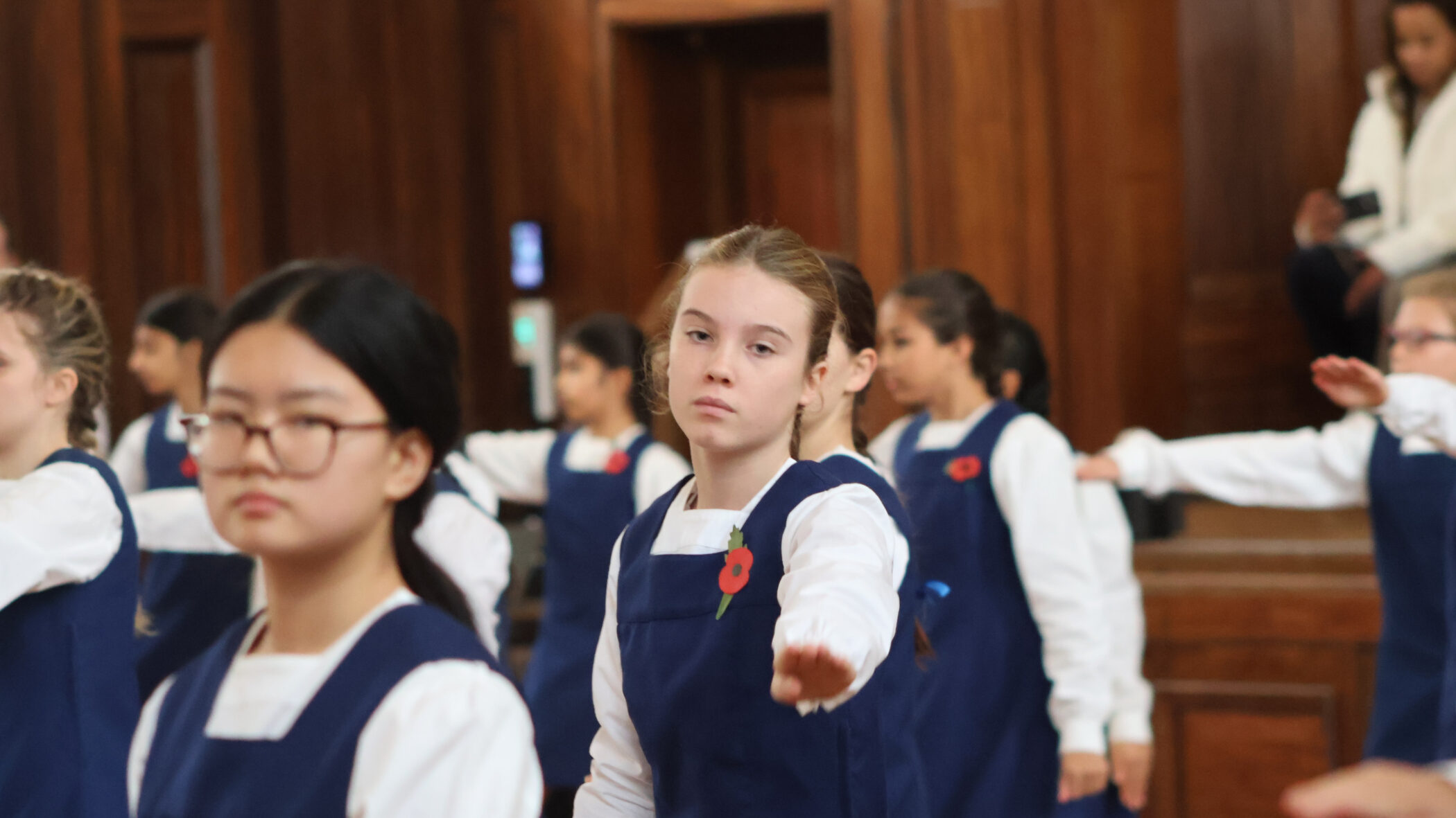 school girls reaching out and wearing poppies