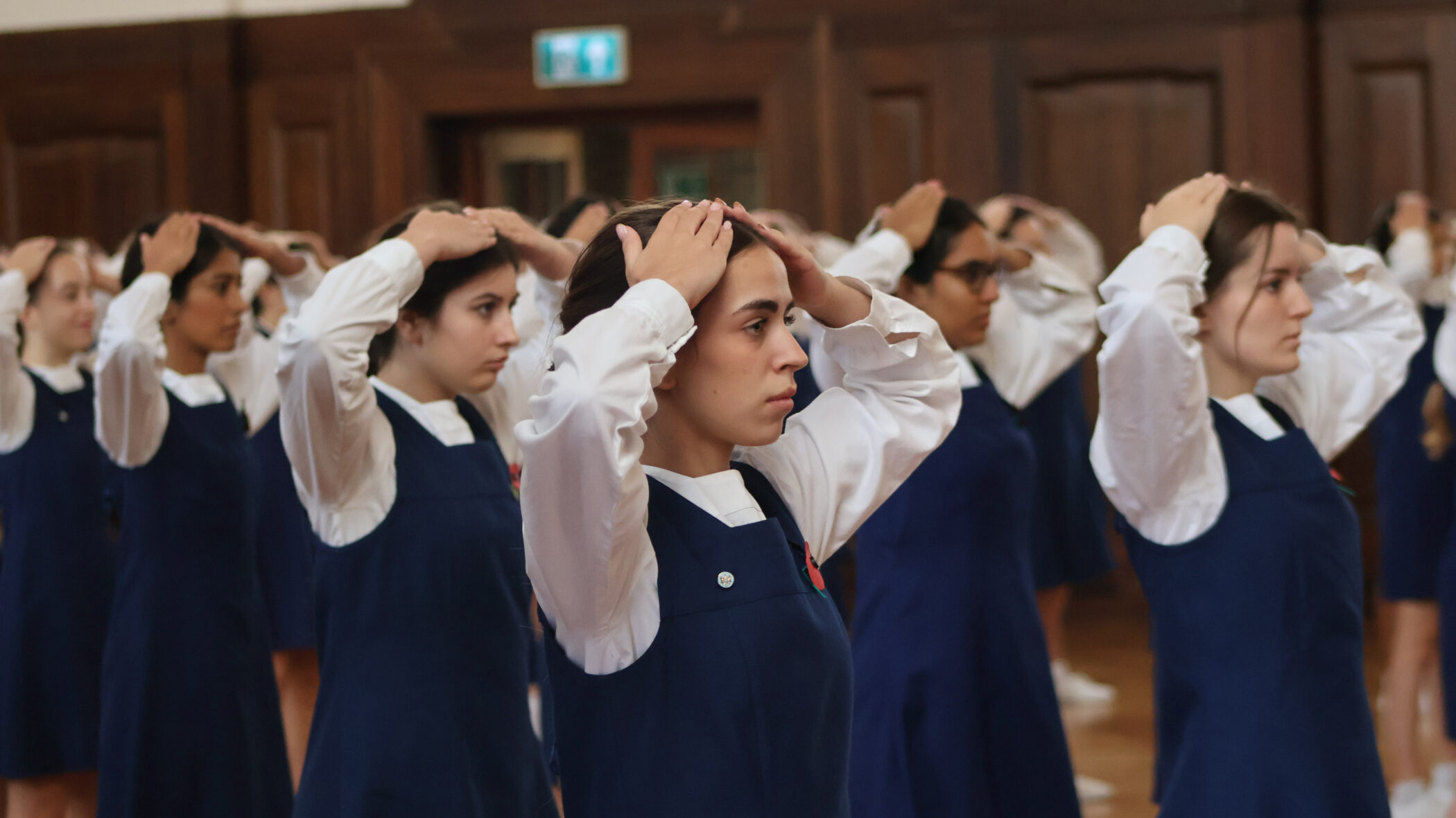 group of school girls holding their hands on their head