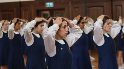 group of school girls holding their hands on their head