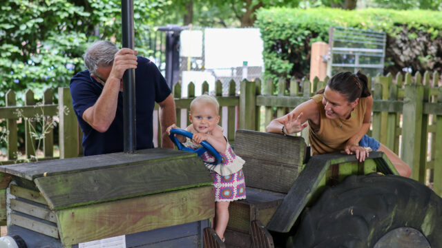 toddler sitting on a wooden tractor