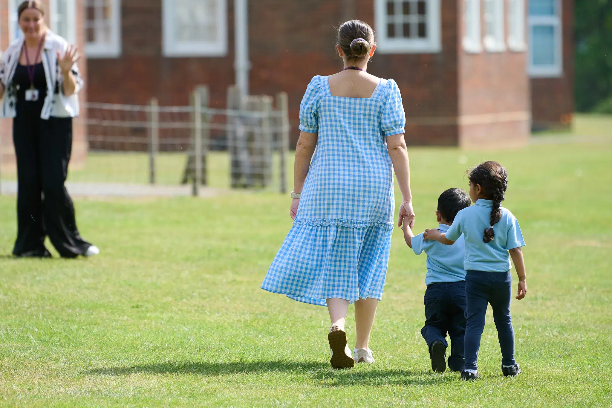 What is pastoral care in schools? An RMS Nursery teacher walks across a sun-lit field holding hands with Nursery pupils